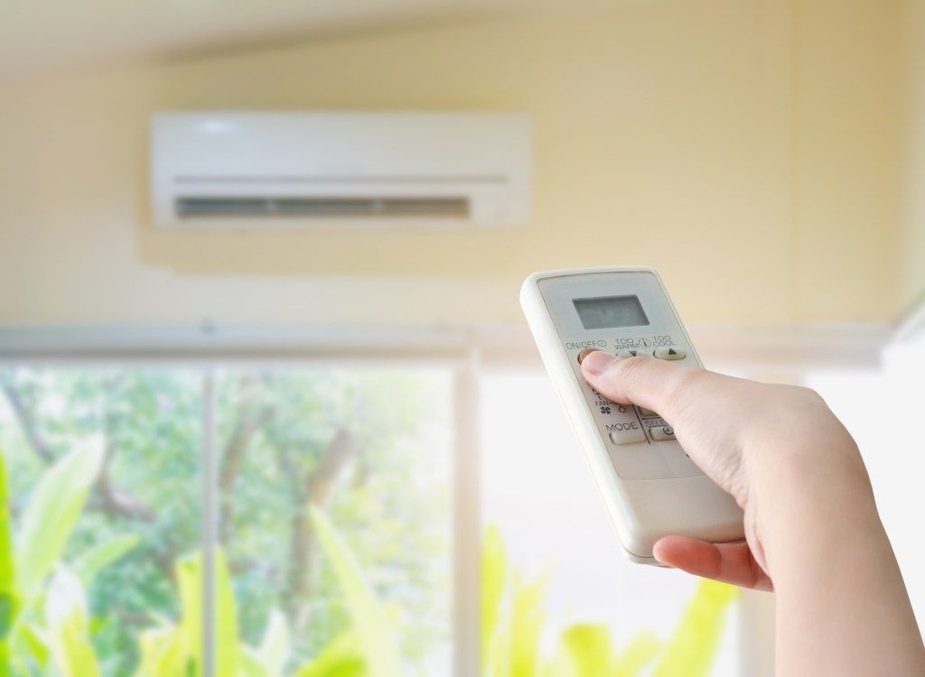 kvinna stänger av mini split luftkonditionering, hem uppgraderingar