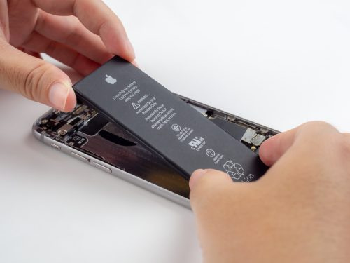   Chiang Rai, Tai: 13. september 2018 – lähivõte tehniku ​​kätest, kes üritasid eemaldada, võtta, vahetada või asendada Apple iPhone 6 aku degenereerunud või kahjustatud.