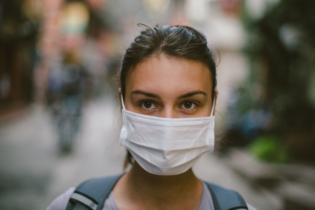 mladá žena na sebe masku z dôvodu znečistenia, charity pre deň Zeme