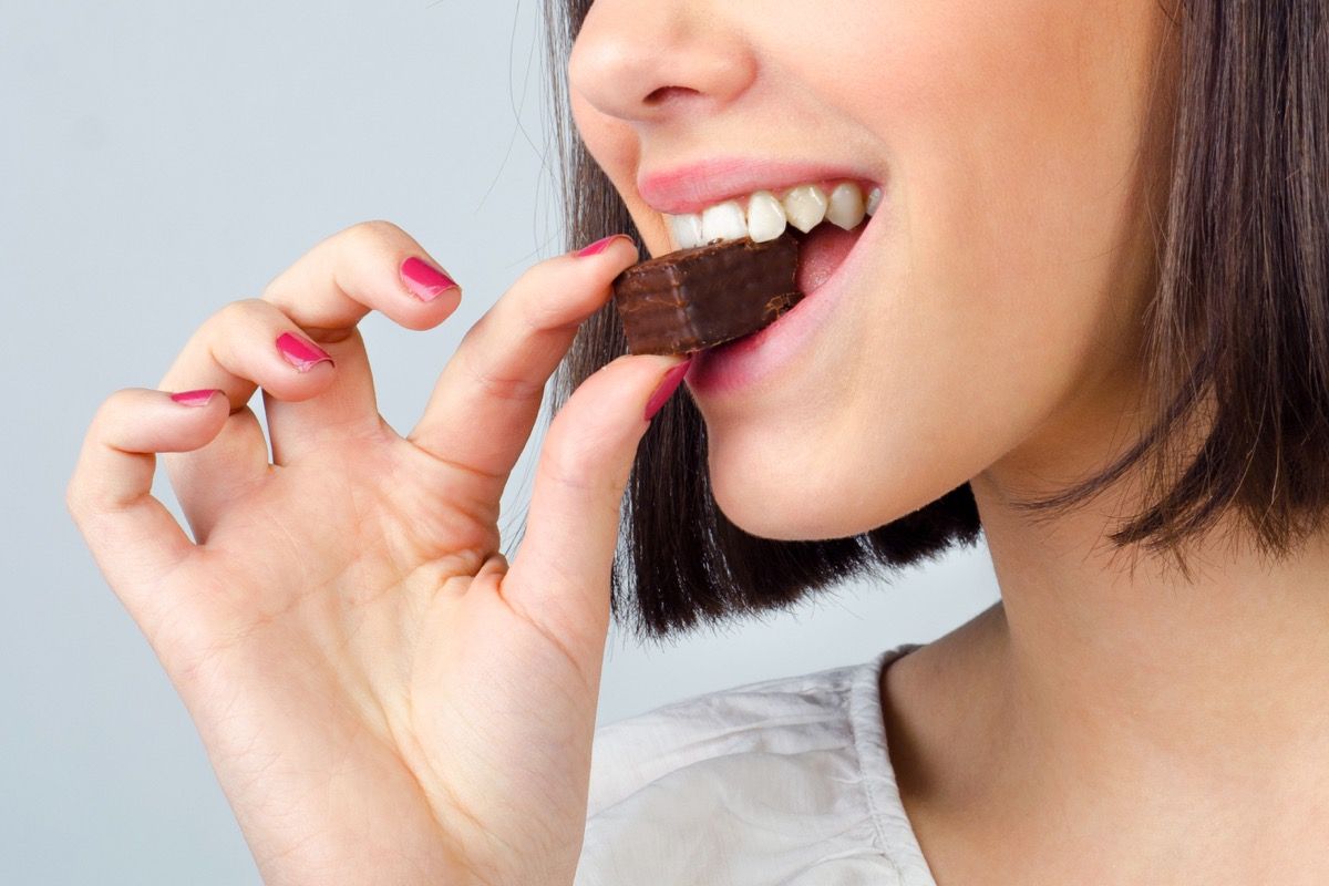 Nainen syö suklaapalaa