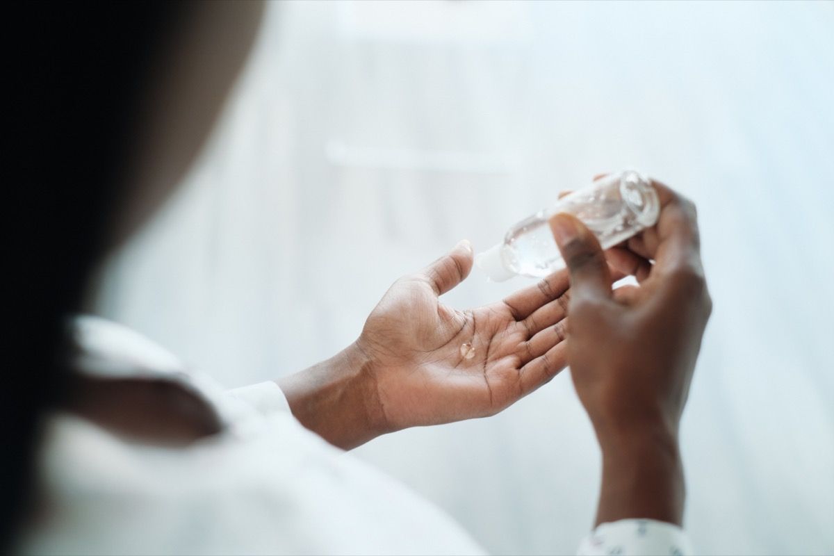 mujer que usa desinfectante de manos líquido. Chica usando gel a base de alcohol para desinfectar la piel de las manos contra virus, gérmenes y bacterias para un estilo de vida saludable