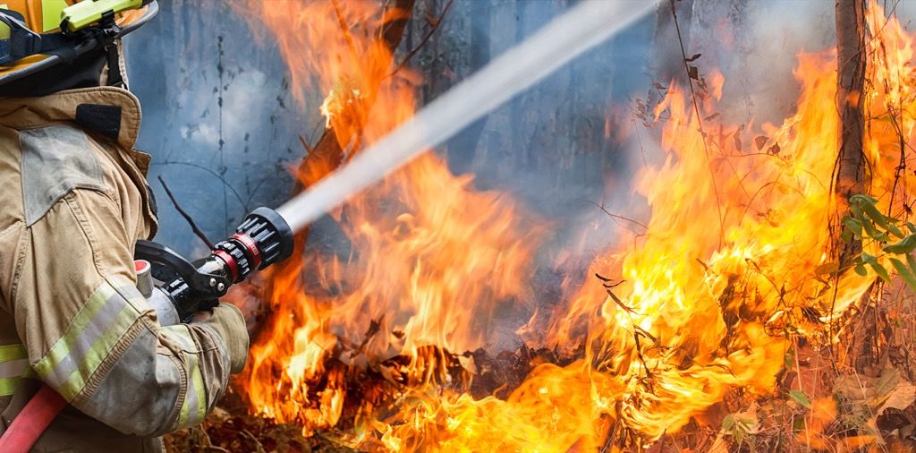 Пожарникарят излива вода в огън