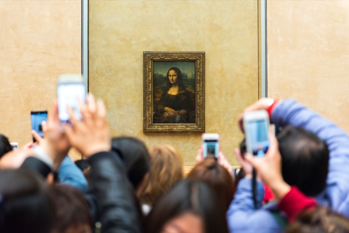 люди пытаются сфотографировать Мона Лизу