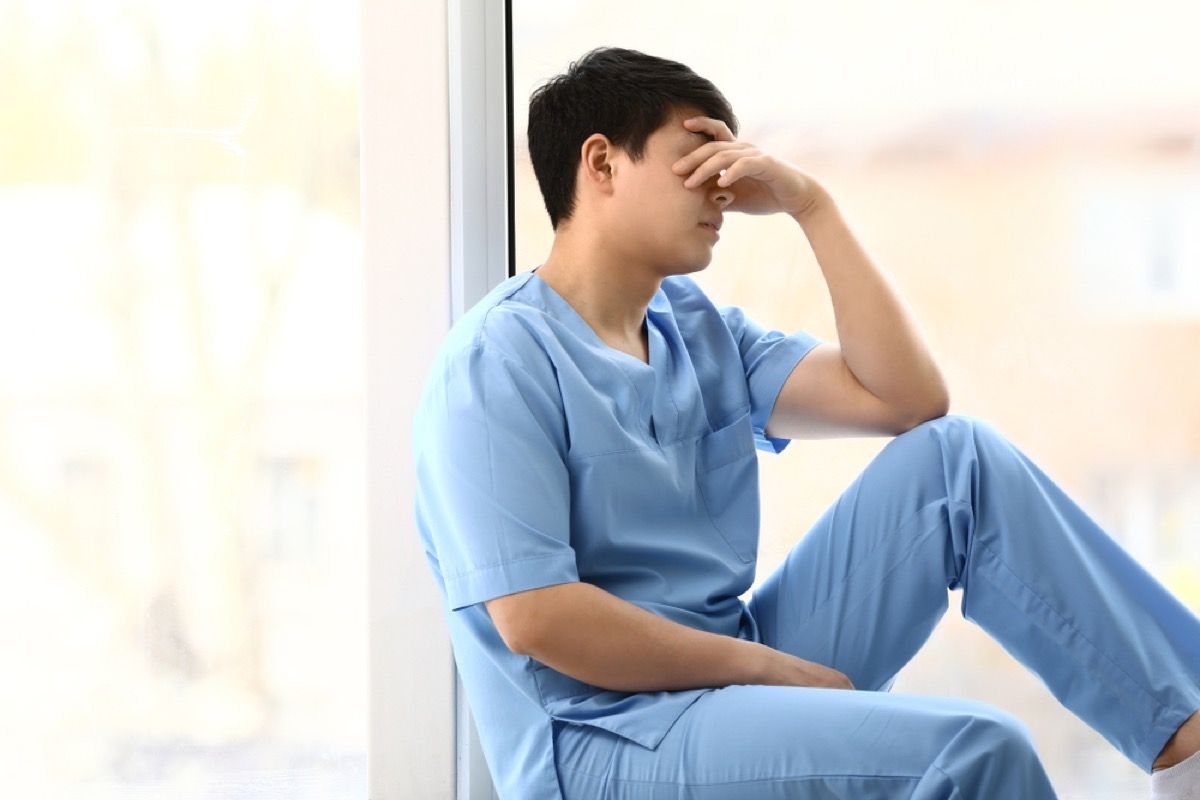 pria stres di scrub duduk di lorong, rahasia perawat sekolah
