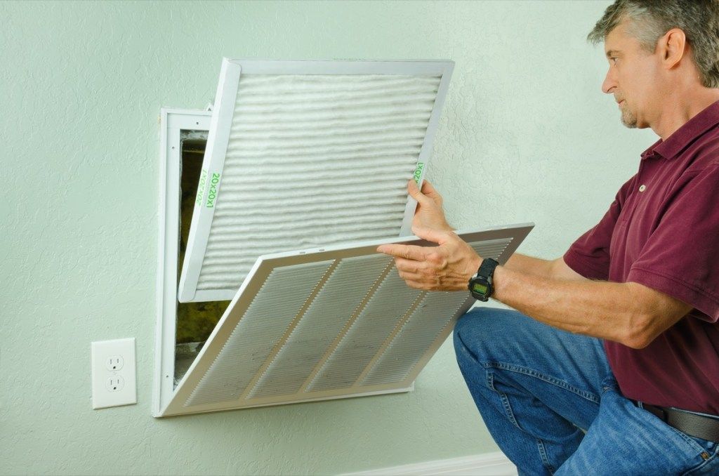 vanhempi valkoinen mies vaihtaa ilmastointisuodatinta