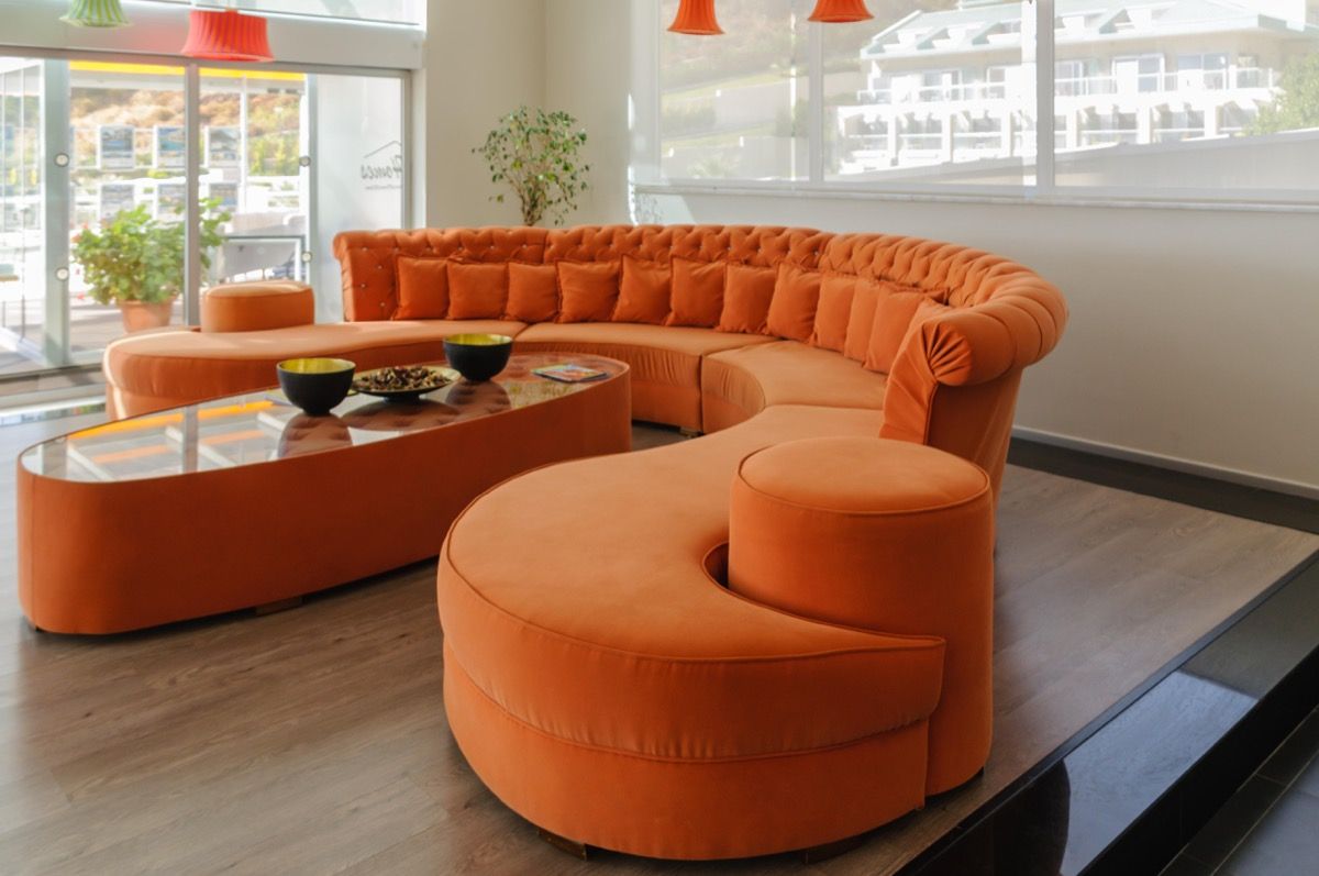 PRCJ5W Narancssárga hajlított kanapé és asztal egy nagy, modern, modern szobában.