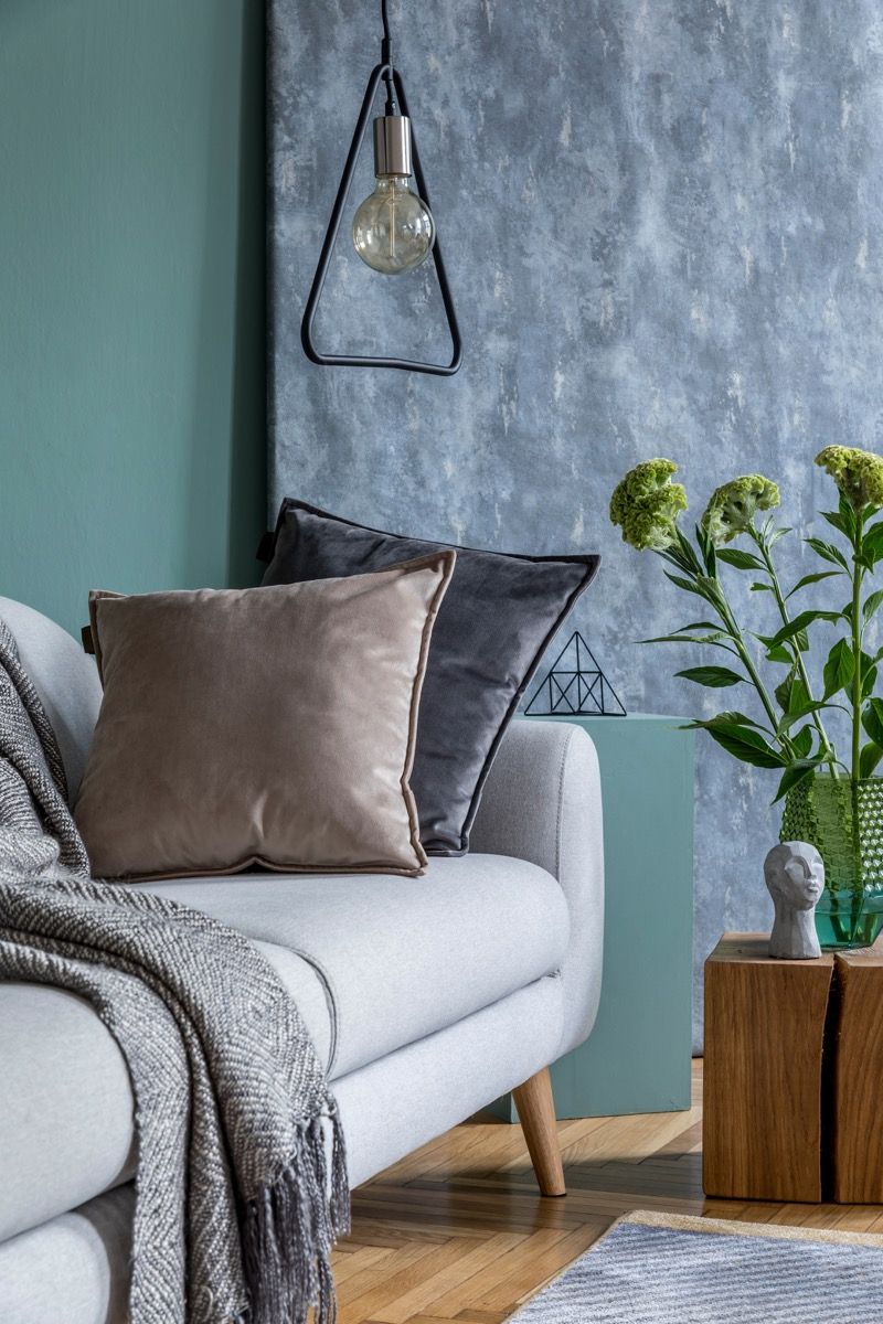 Almofadas de veludo em um sofá azul / cinza Vintage Home Trends