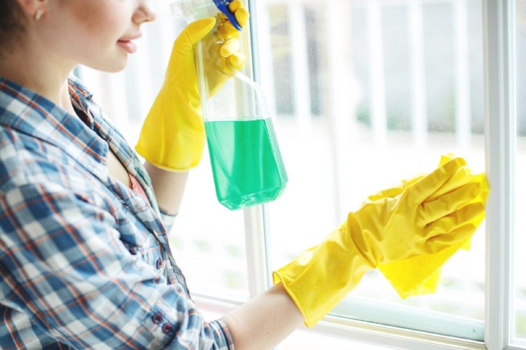 sieviete, noslaukot logu ar tīrīšanas līdzekli, tīrīšanas kļūdas