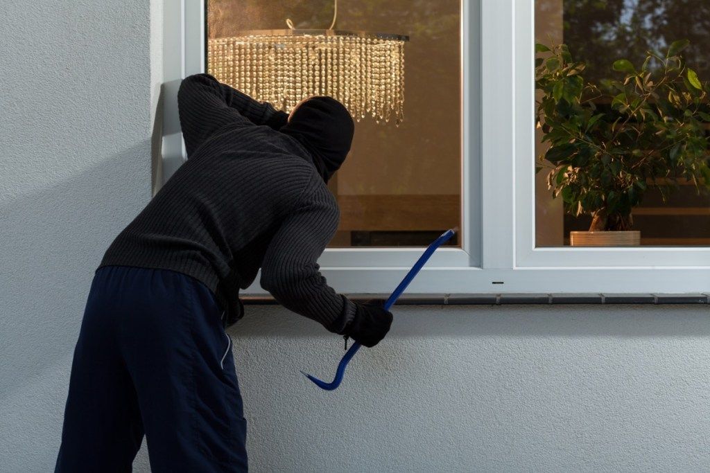 provalnik koji se sprema za ulazak u kuću kroz prozor, sigurnosni savjeti