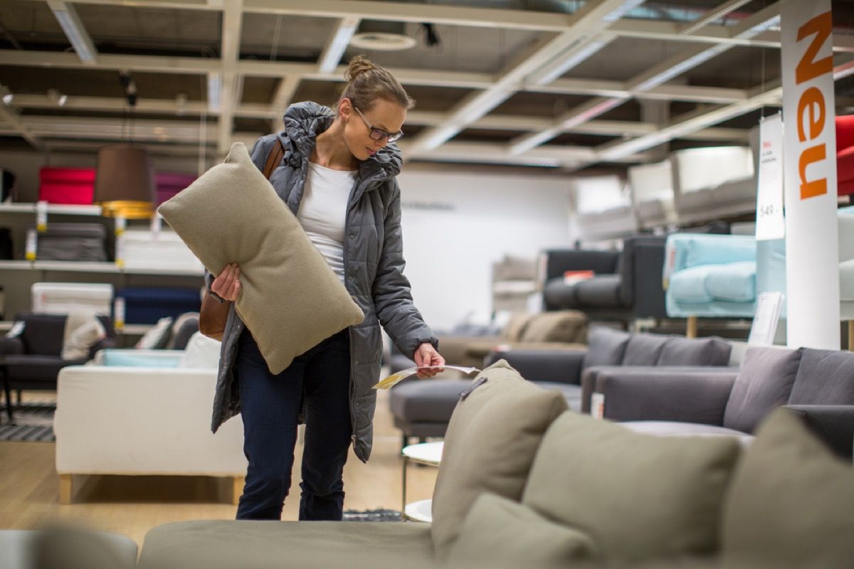 žena kontroluje cenu pohovky při nakupování nábytku