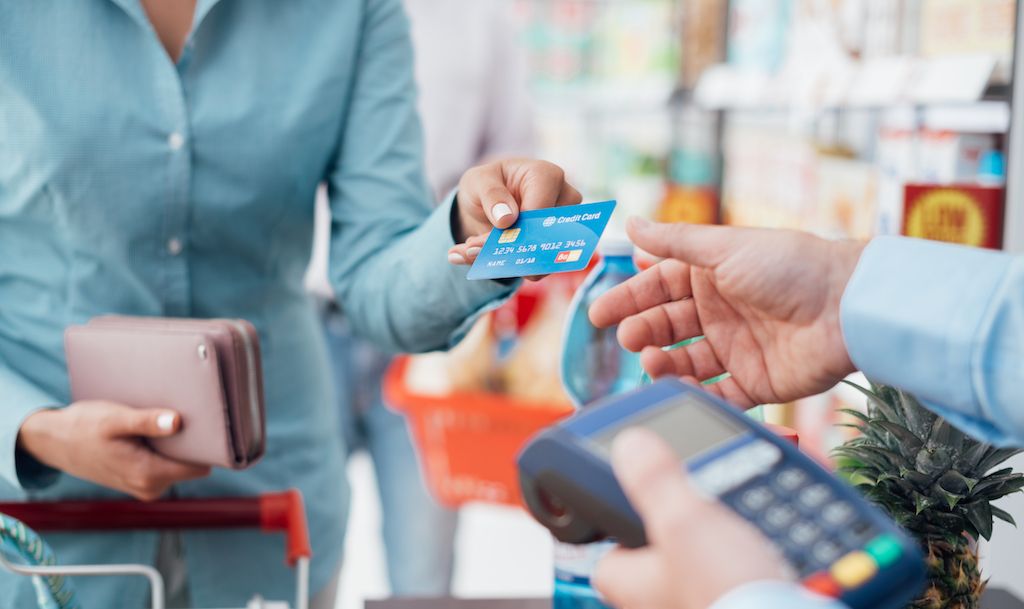 įteikdamas kasininkui kreditinę kortelę