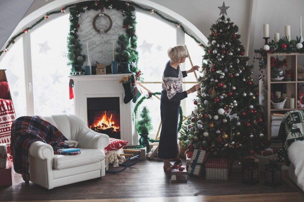 moteris puošia savo namus Kalėdoms