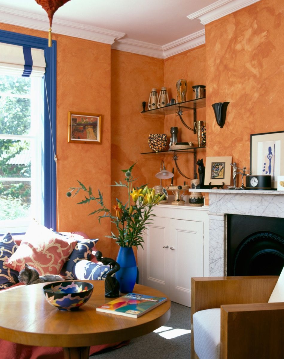 परिपत्र कॉफी टेबल के साथ नब्बे के दशक के रहने वाले कमरे की दीवारों पर स्पंजिंग पेंट का प्रभाव