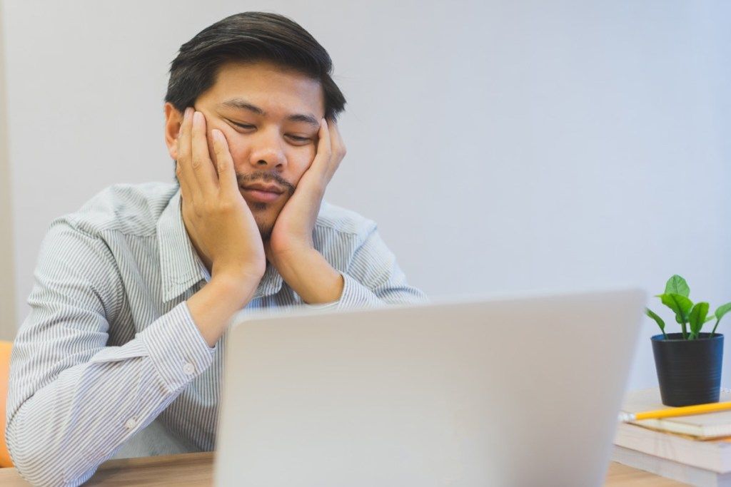 Mannen sitter ved datamaskinen Bored at Work Signs of Burnout