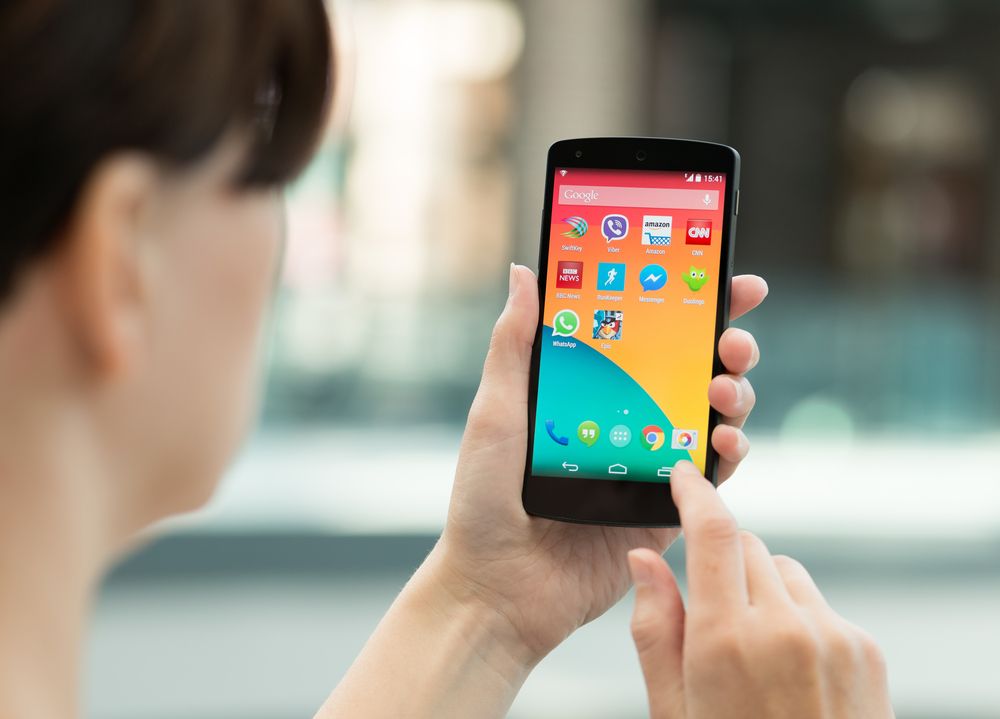 babaeng gumagamit ng android phone mula sa likuran