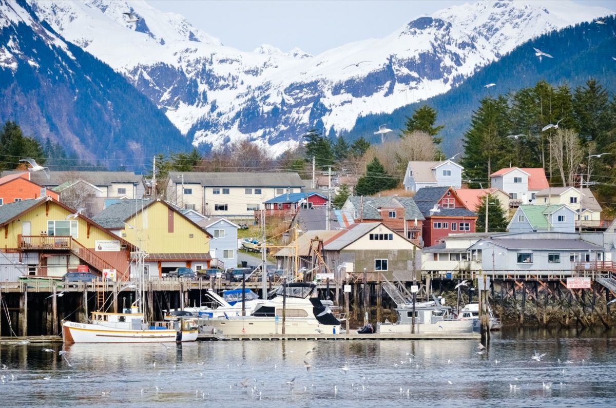 farverige bygninger på en havn med snedækkede bjerge i baggrunden