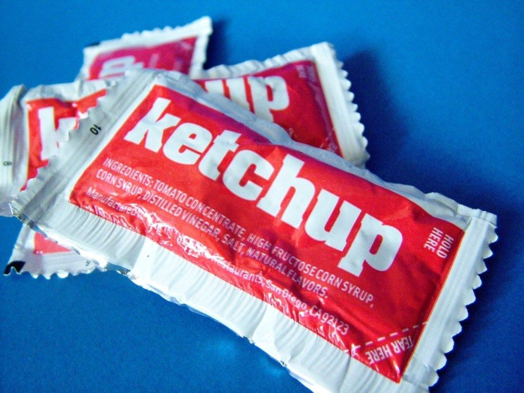 ketchup-pakker mod en blå baggrund