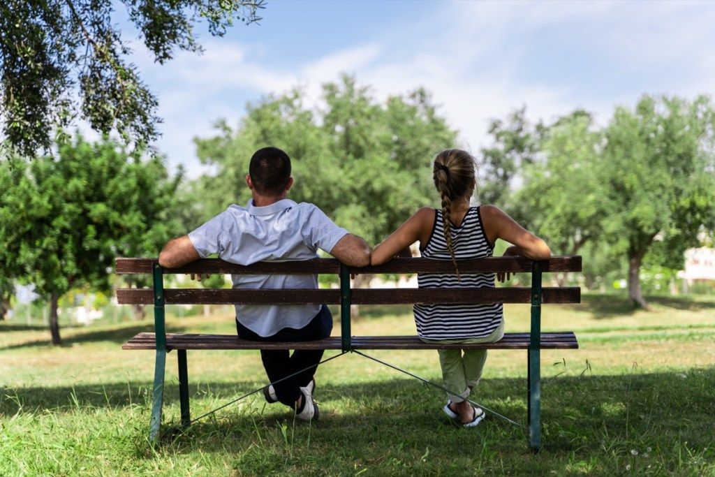 Pora kartu sėdi ant suoliuko parke