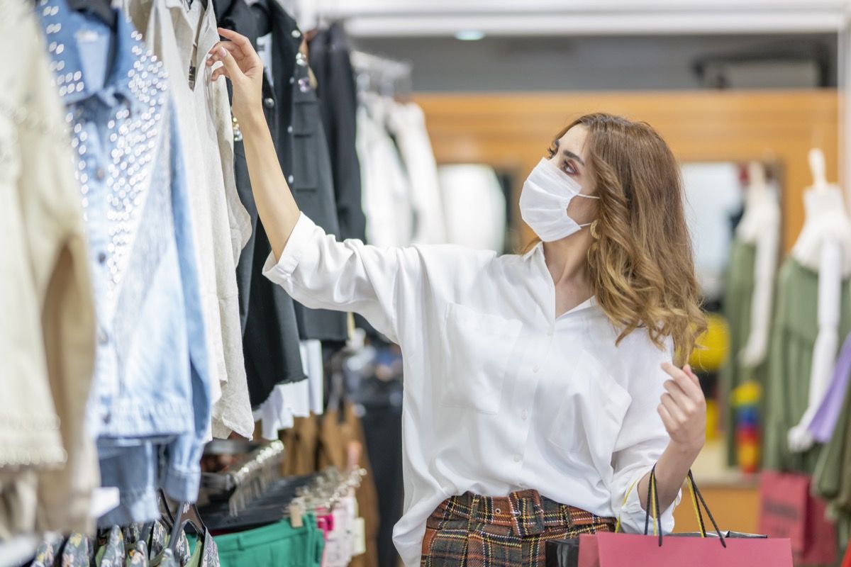 Mladá žena nosí ochrannú masku pri nákupe v obchodnom centre.