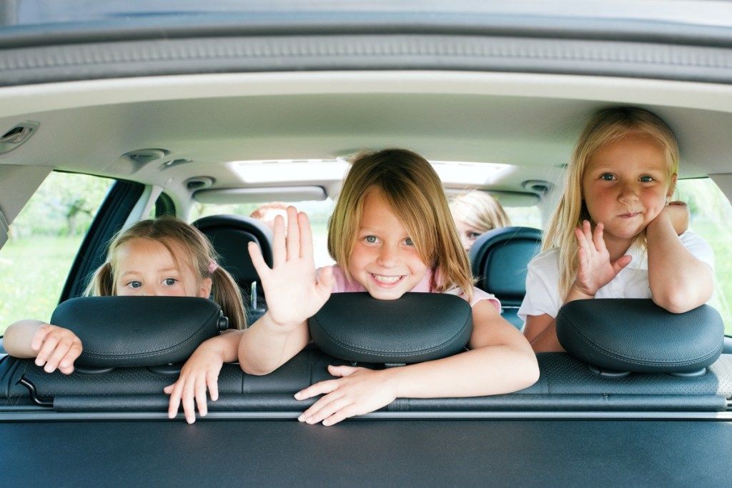 трима братя и сестри в кола заедно, средно дете