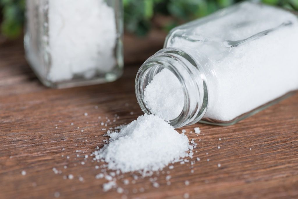 Pengocok garam tumpah di atas meja kayu