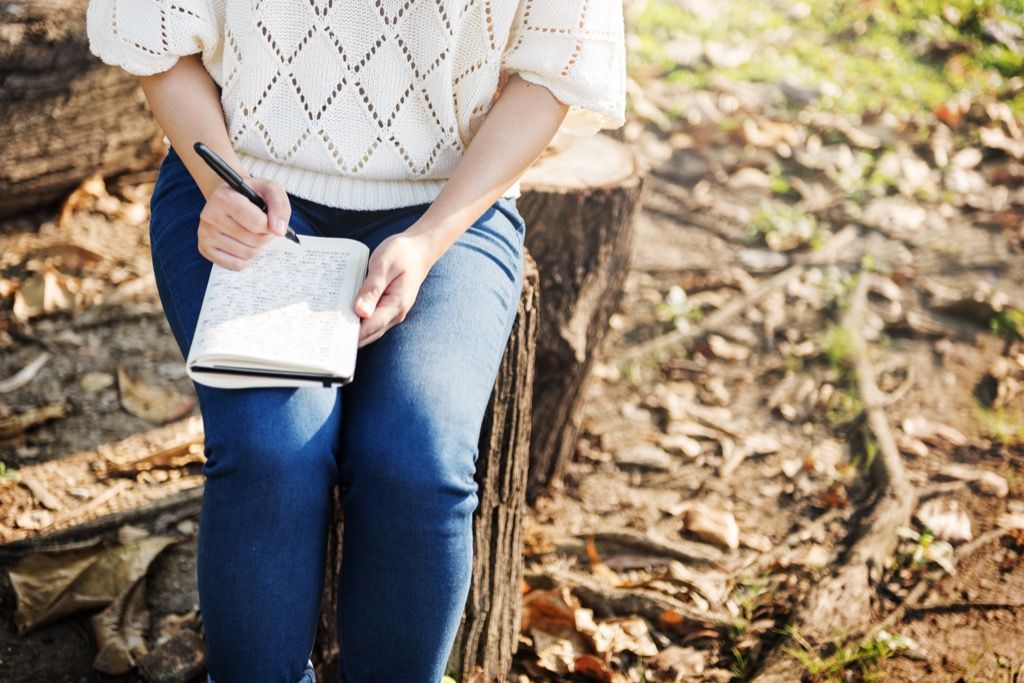 Ženska, ki piše v svojem dnevniku, produktivno zavlačuje