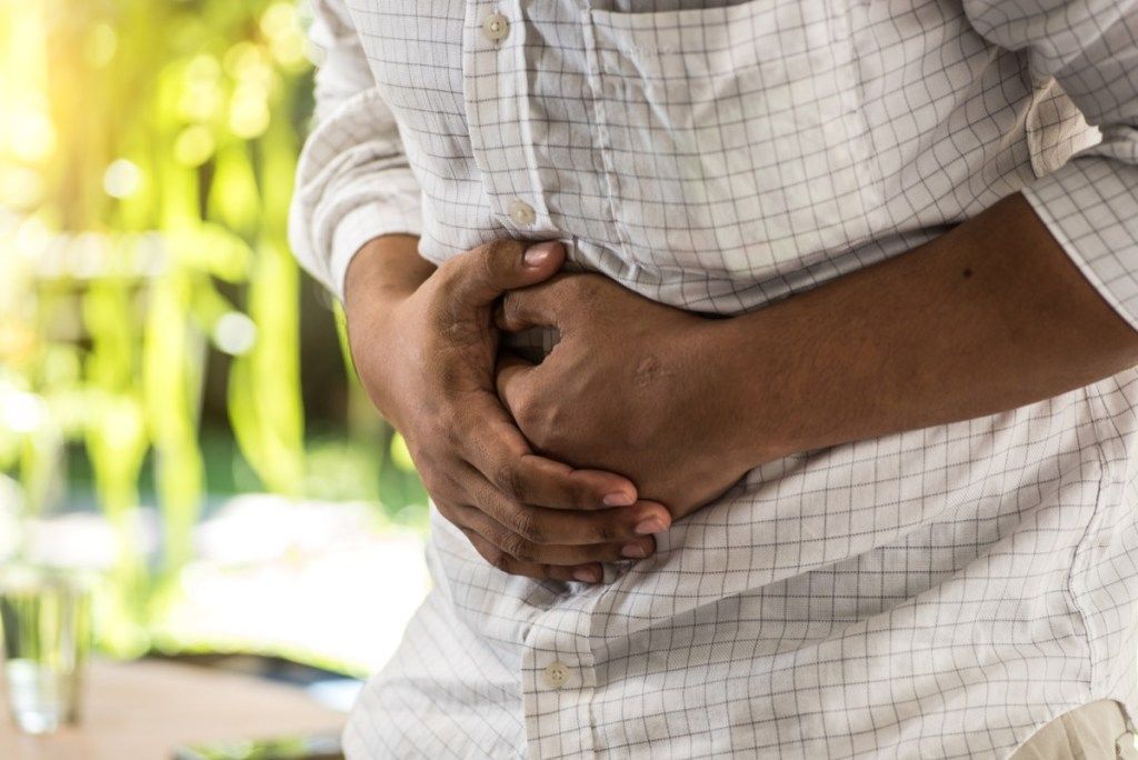 Omul care își ține stomacul în durere, întrebări de sănătate după 40 de ani