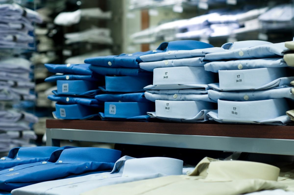 Camisas de botones dobladas azules en un estante en una tienda