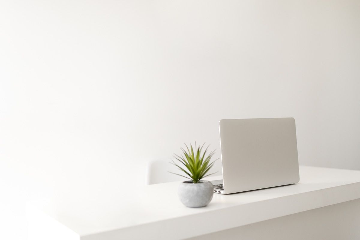 oficina en casa minimalista blanca con computadora portátil de mesa