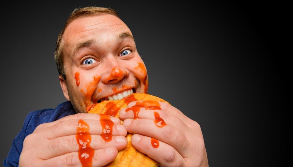 Người đàn ông với thức ăn trên khuôn mặt của mình sai lầm nghi thức BBQ