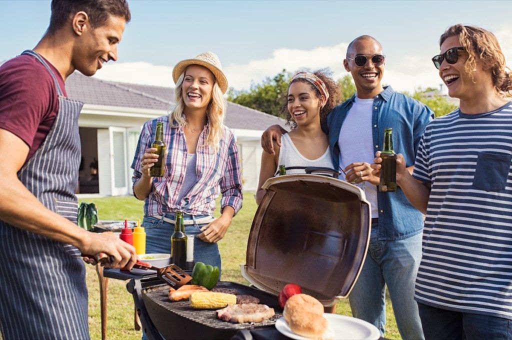 Barátok lógnak a grill mellett egy barbecue BBQ etikett hibáinál