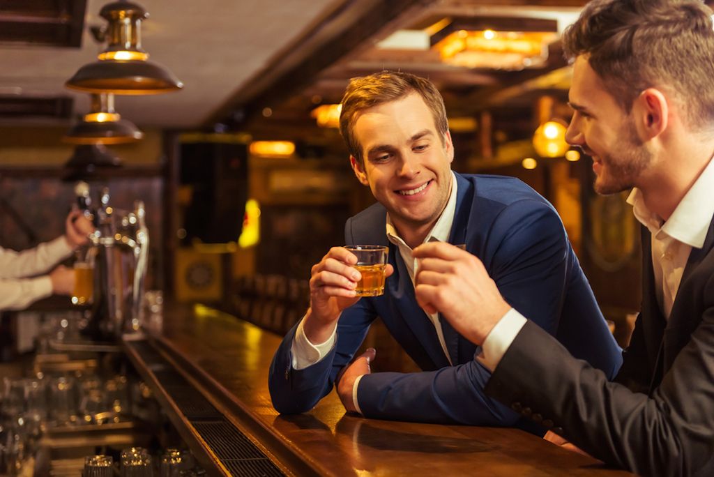 двама бизнесмени пият в бар