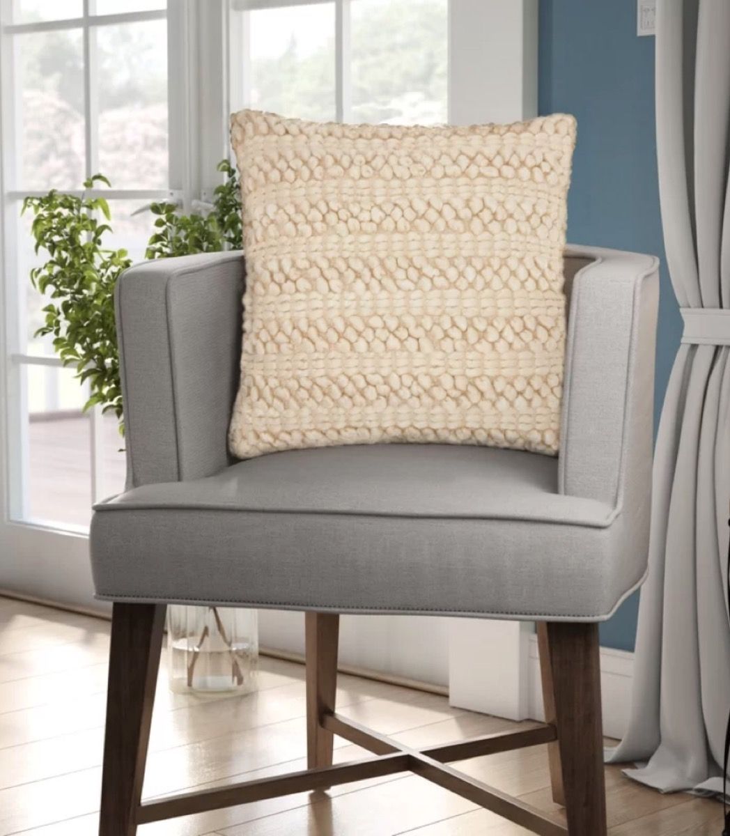 silla gris con almohada de color canela a rayas