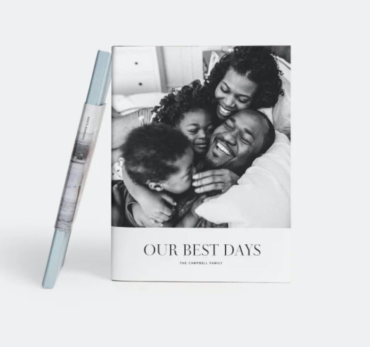 valokuvakirja, jossa on hymyilevä musta perhe mustavalkoisena valokuvana kannessa