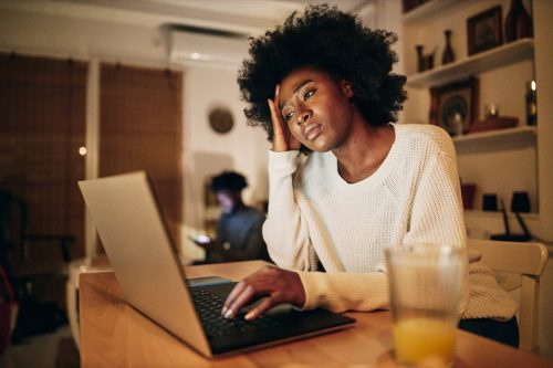   mujer haciendo trabajo independiente en una computadora portátil y luchando con un problema