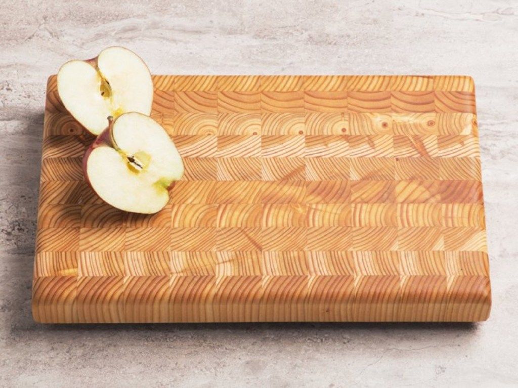 Manzana dividida en dos sobre tabla de cortar de madera, decoraciones de cocina