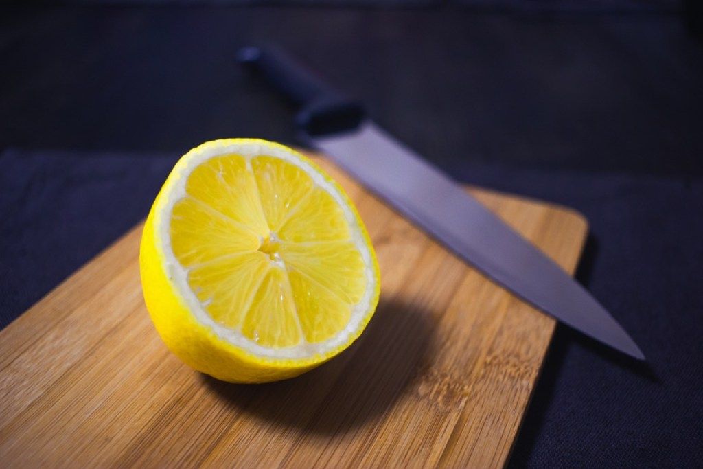 limón sobre tabla de cortar, consejos de limpieza de la vieja escuela