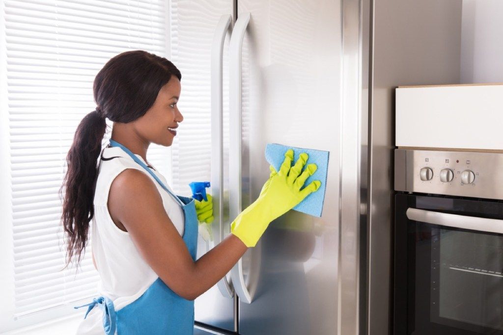 moteris valanti šaldytuvą, senosios mokyklos valymo patarimai