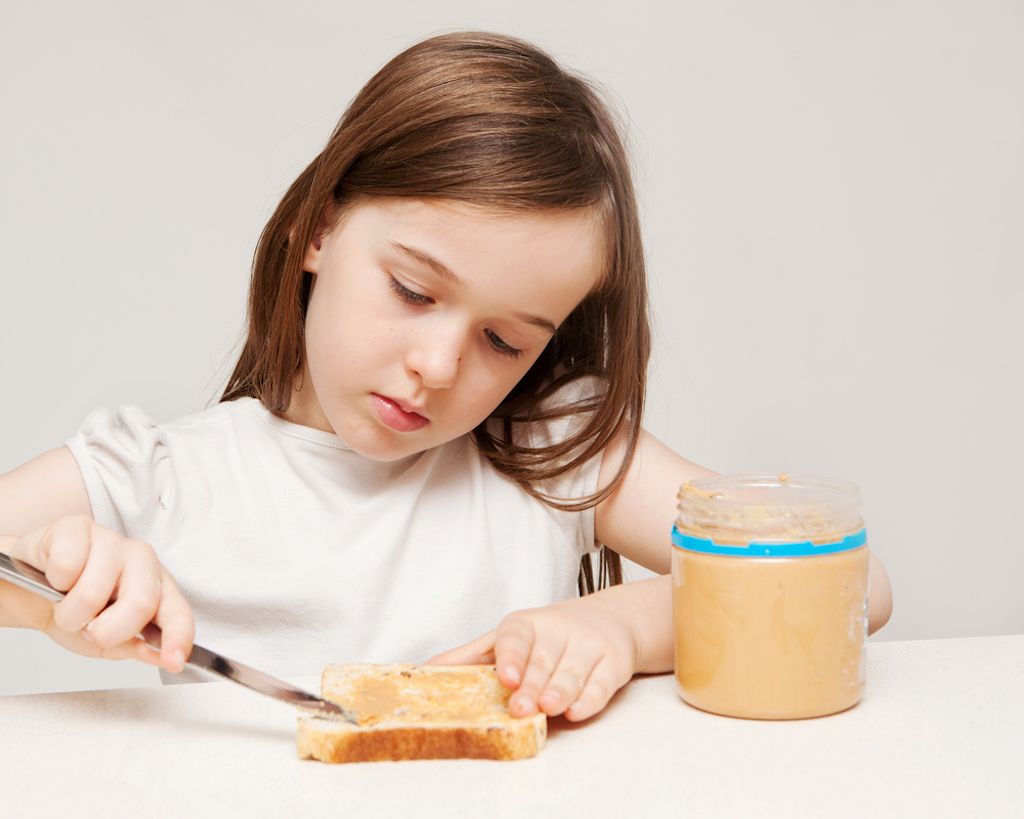 noia fent sandvitx de mantega de cacauet, la criança és més difícil