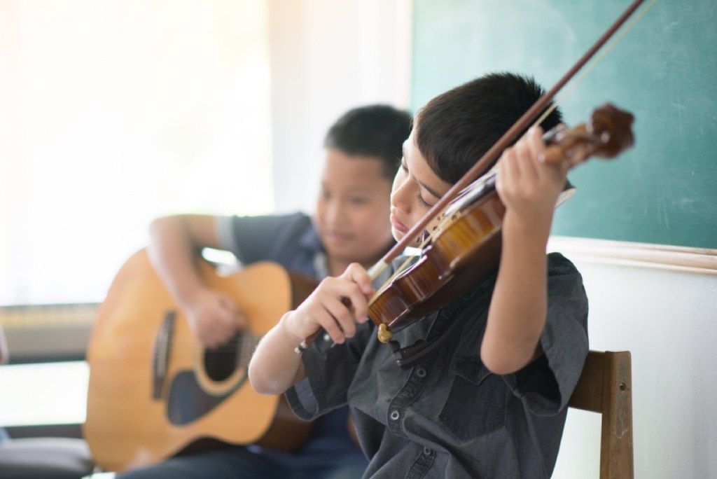 dua anak laki-laki bermain biola dan gitar, mengasuh anak lebih sulit