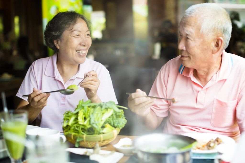 pria dan wanita yang lebih tua makan di restoran hot pot, kesalahan etiket