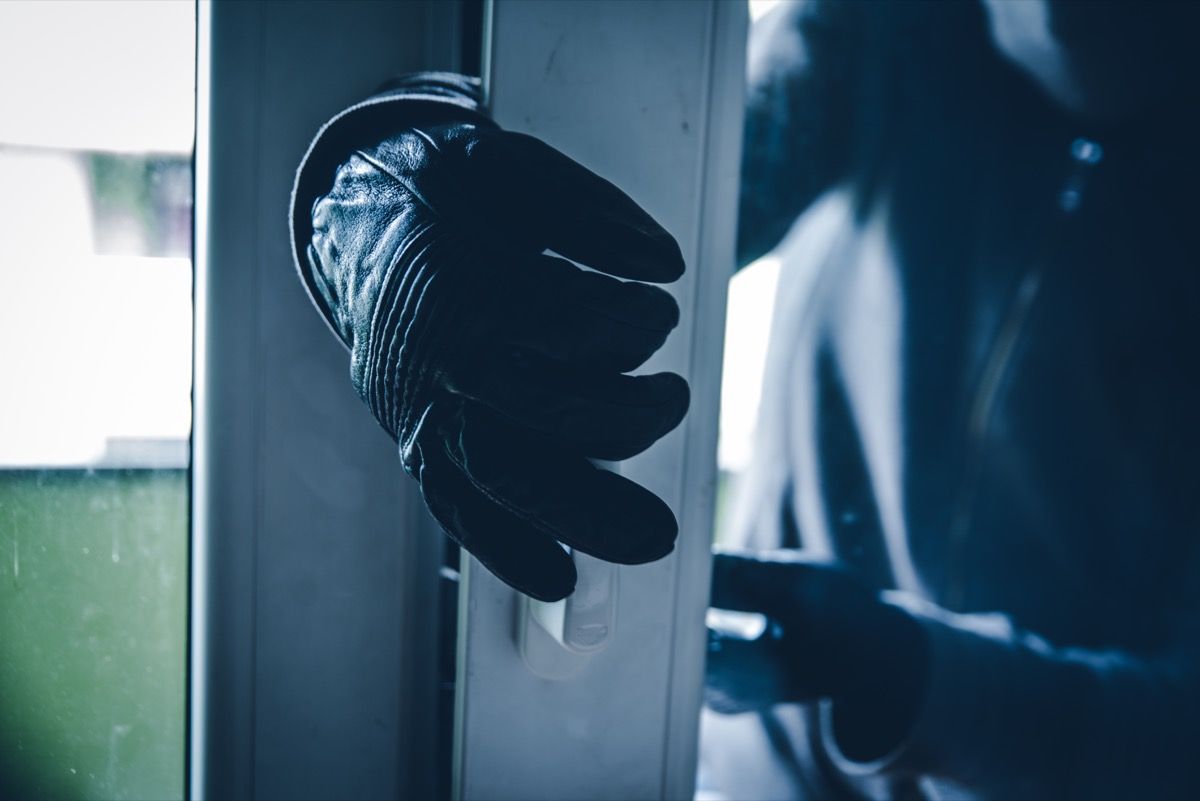 ladrón irrumpiendo en casa con sus guantes abrir una puerta