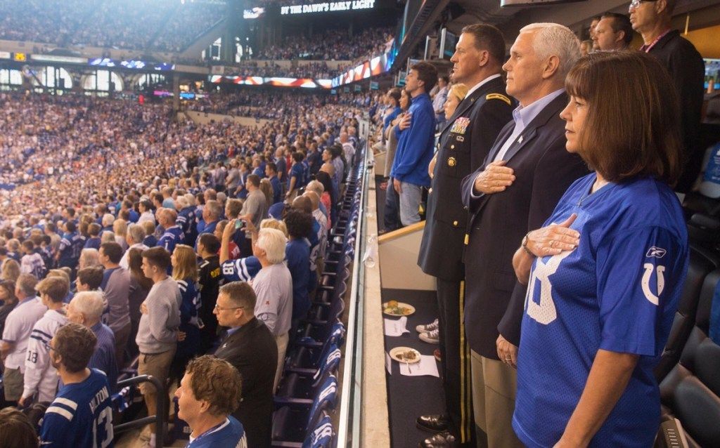 Mike Pence amerikai alelnök, felesége, Karen Pence és Courtney P. Carr vezérőrnagy a nemzeti himnusz elénekléséért áll a Lucas Oil Stadionban, mielőtt az Indianapolis Colts játék megkezdődött a San Francisco 49ers ellen 2017. október 8-án Indianapolisban. , Indiana.
