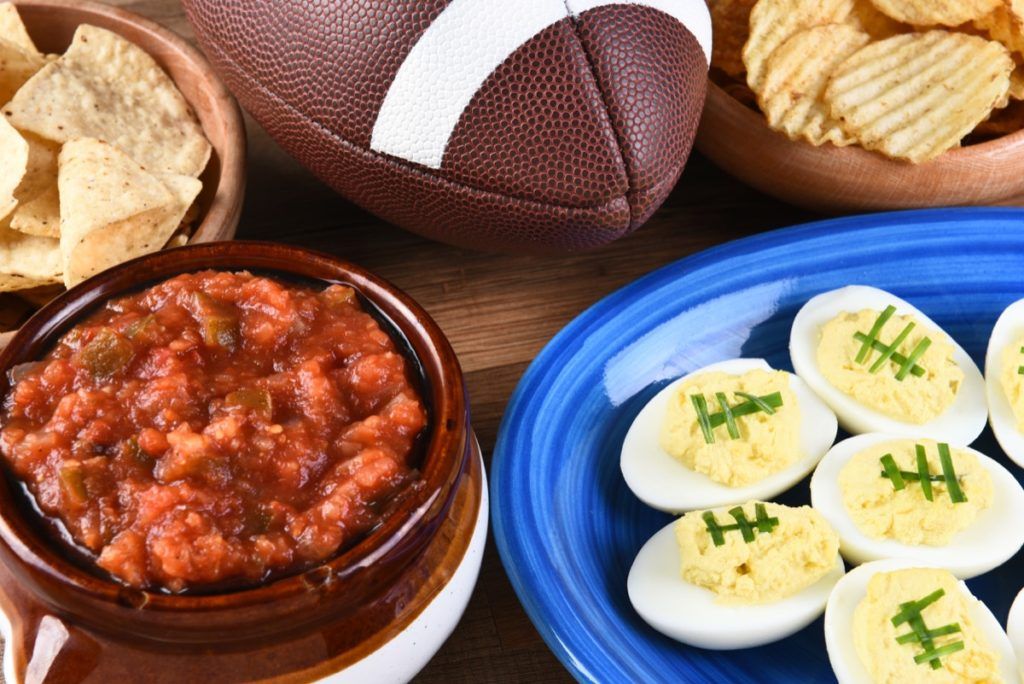 Čipsi, salsa un velnišķīgas olas, kas izliktas Super Bowl