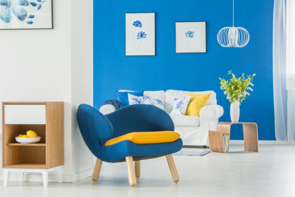 moderna māja ar zilu sienu un ziliem krēsliem