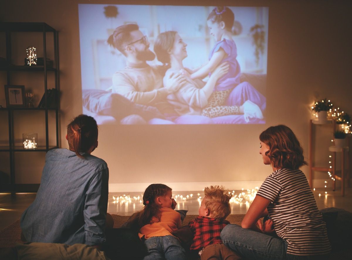 Perhe katselee projektoria kotona