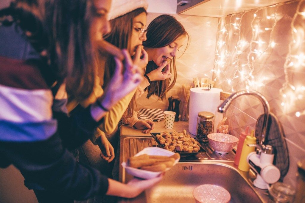 mujeres comiendo pollo en una fiesta navideña
