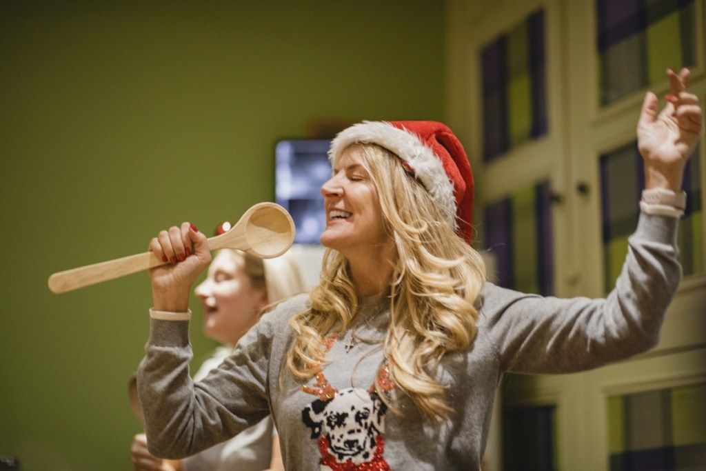 mulher cantando em uma colher de pau em uma festa de Natal