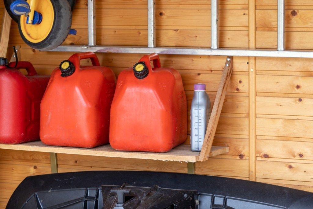 Latas de gas rojo en el estante del garaje