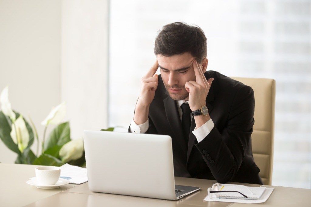 Stresovaný muž na počítači podepisuje, že vás váš šéf chce vyhodit
